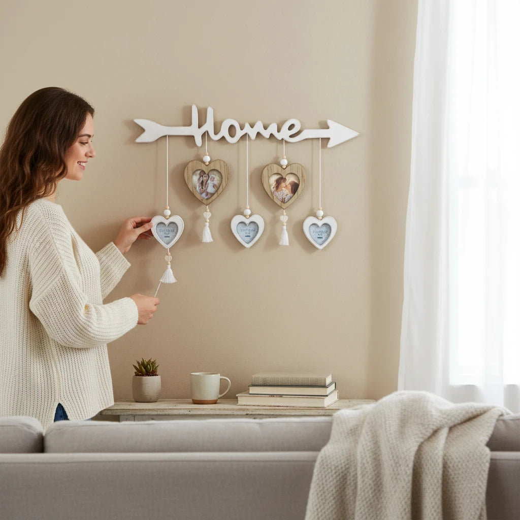 Donna appende una cornice multifoto FotoGrafica in legno a forma di cuore con scritta Home su una parete beige