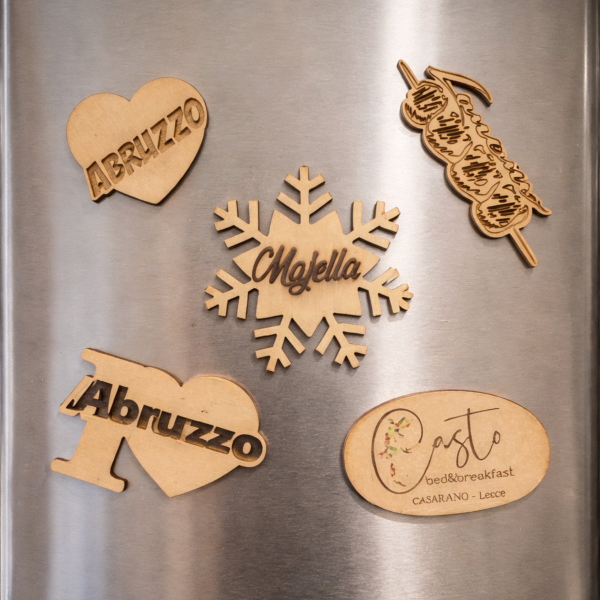 Set di calamite personalizzate in legno FotoGrafica con forme a cuore, fiocco di neve e scritte incise su frigorifero