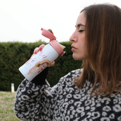 Ragazza beve da una borraccia FotoGrafica bianca personalizzata con foto e nome, tappo rosa, sfondo naturale