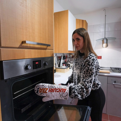 Donna indossa un guanto da forno personalizzato FotoGrafica con scritta Auguri Zia davanti a un forno in cucina