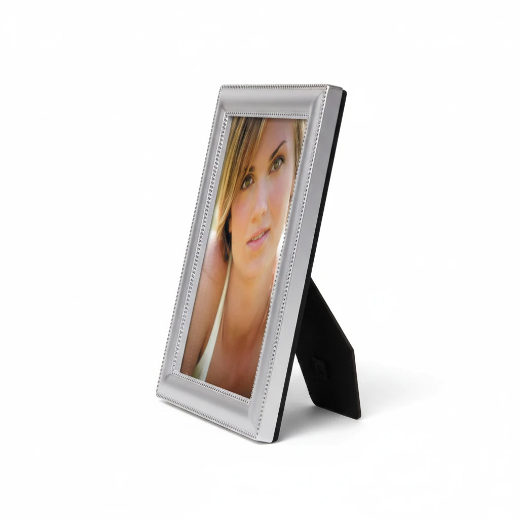 Portafoto da tavolo FotoGrafica in argento lucido con design minimalista e bordo decorato, vista laterale.
