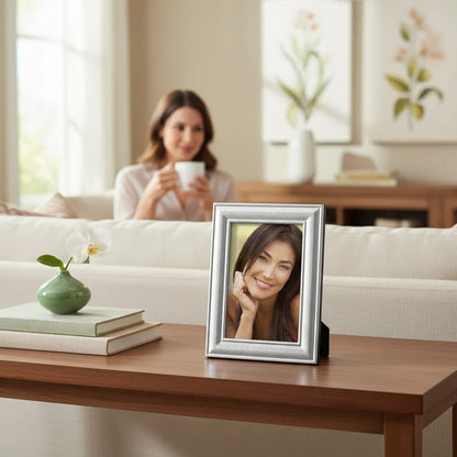 Portafoto da tavolo FotoGrafica color argento con finitura lucida e design minimalista su un tavolo in legno