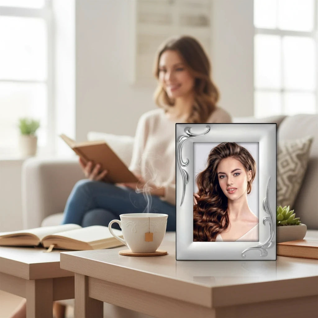 Portafoto da tavolo FotoGrafica in argento lucido con decorazioni floreali eleganti su un tavolino da salotto