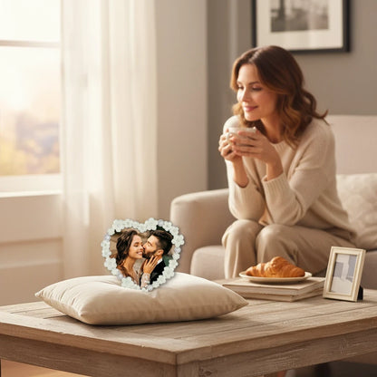 Cornice da Tavolo Love FotoGrafica a forma di cuore con decorazioni floreali su un cuscino in un salotto accogliente