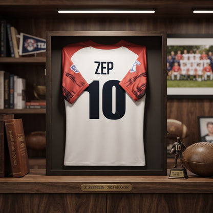 Cornice espositore FotoGrafica in legno scuro per maglia sportiva bianca e rossa con numero 10, stile elegante.