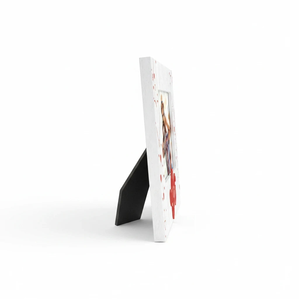 Cornice da tavolo FotoGrafica Love in legno bianco con decorazioni a cuori rossi vista di profilo