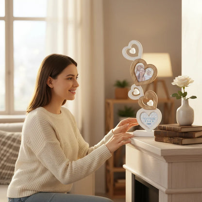 Donna sorridente osserva una cornice multifoto FotoGrafica a forma di cuore in legno e argento su un camino