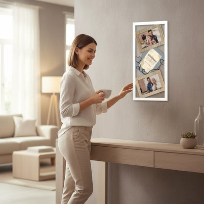 Donna sorridente ammira la cornice multiframe FotoGrafica in legno chiaro appesa in un elegante soggiorno moderno