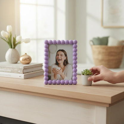 Cornice portafoto da tavolo FotoGrafica color lilla con bordo decorato a sfere su mobile in legno