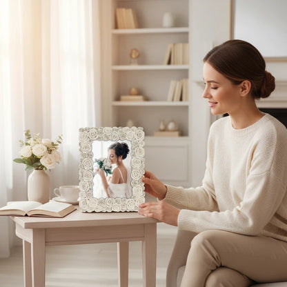 Donna sorridente tiene una cornice portafoto da tavolo FotoGrafica decorata con rose bianche in un salotto luminoso