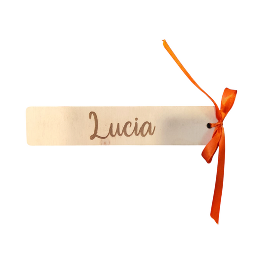 Segnalibro personalizzato in legno FotoGrafica con nome inciso e nastro arancione decorativo su superficie in vetro